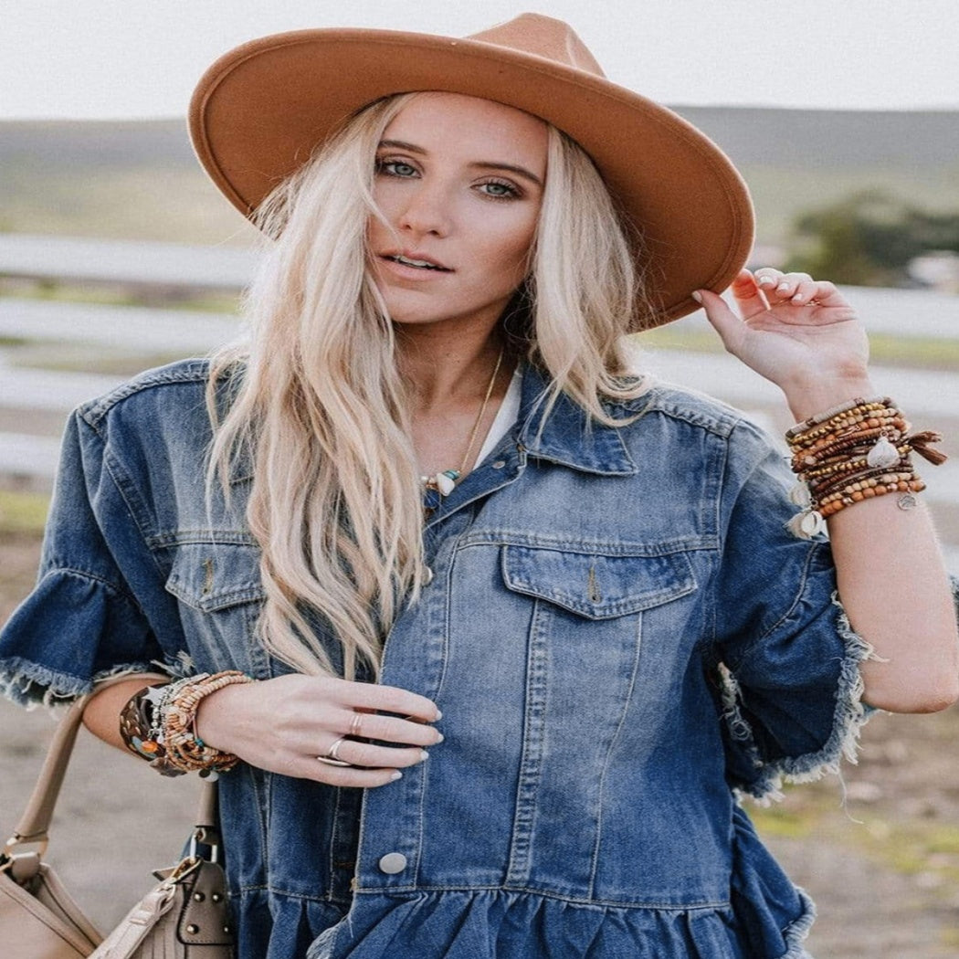 Loose denim ruffled short sleeves top for women, paired with a wide-brim hat and layered bracelets for a boho casual look.