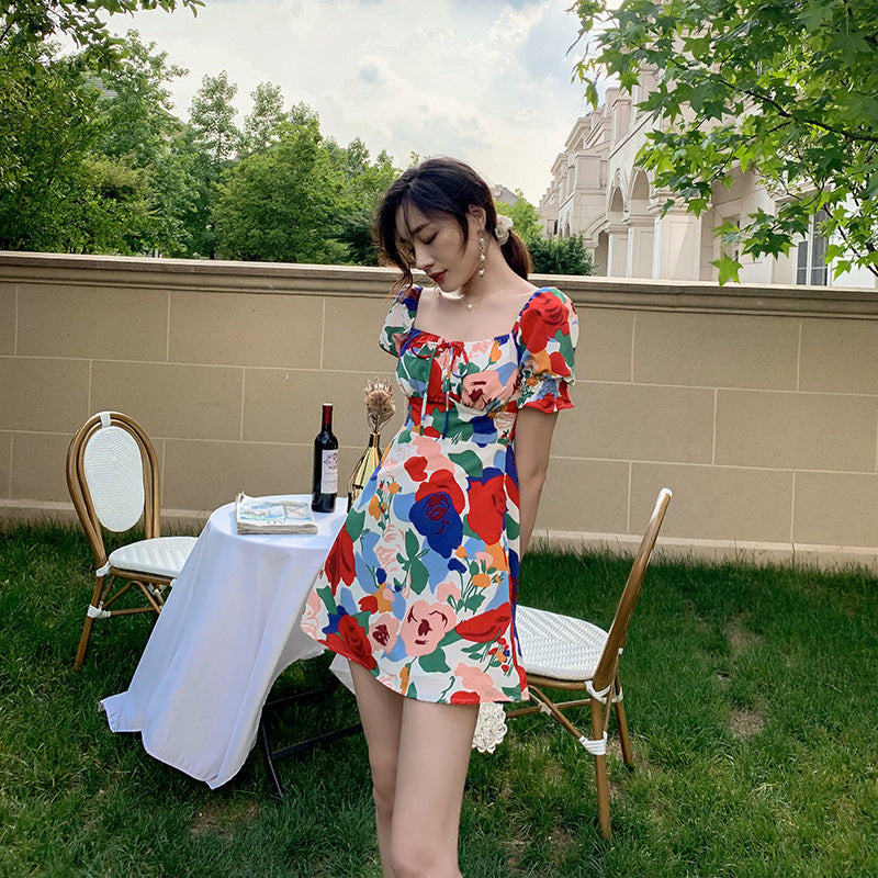 Womens summer puff sleeve square neck dress with floral design, worn at a garden table setting for a relaxed summer vibe.