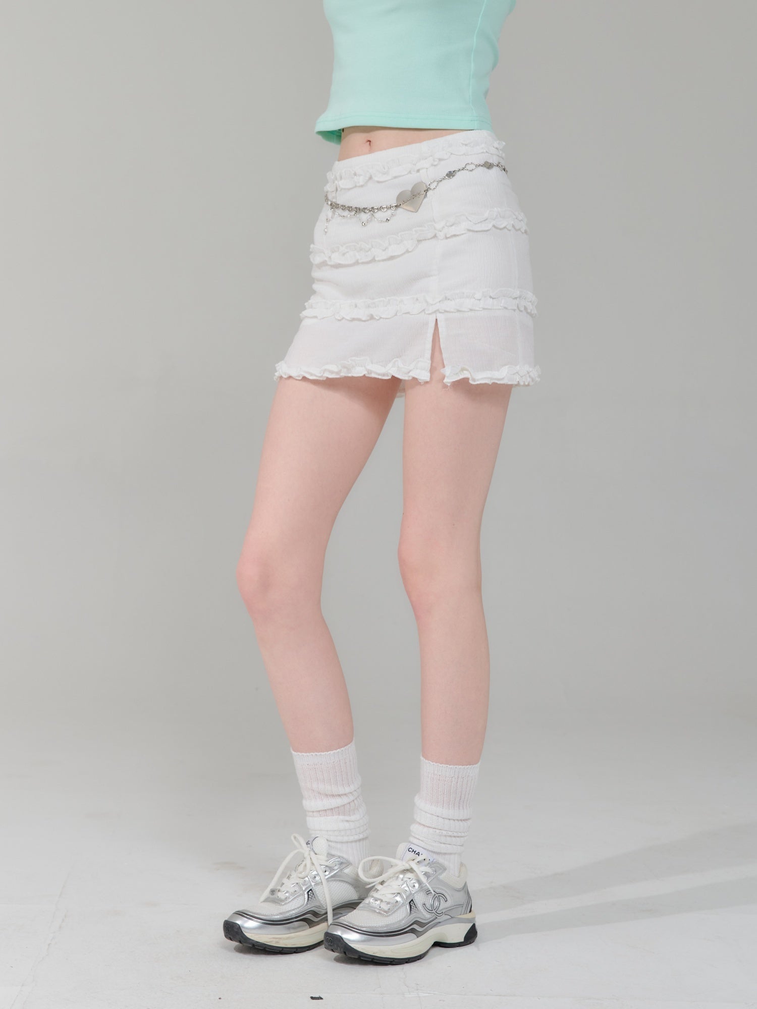 Side view of retro hip-wrapped skirt for women featuring layered ruffles and front slit, styled with sneakers for a trendy look.