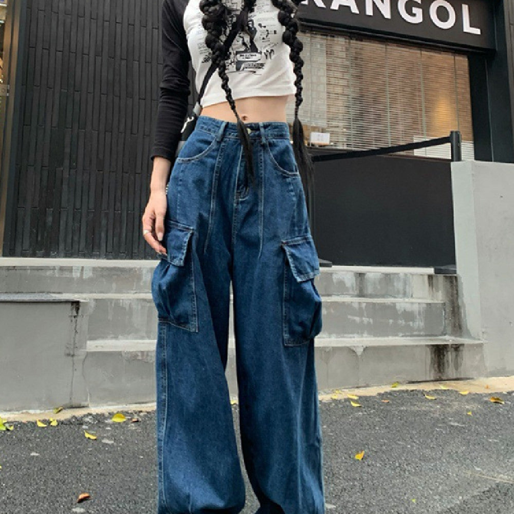 Fashionable loose wide-leg pants for women in denim with large side pockets, styled for casual streetwear with a crop top and sneakers.