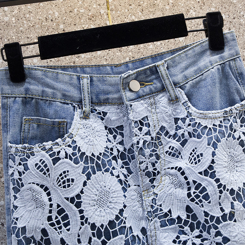 Close-up of patchwork denim draping pants for women showing detailed floral lace embroidery and denim button closure.