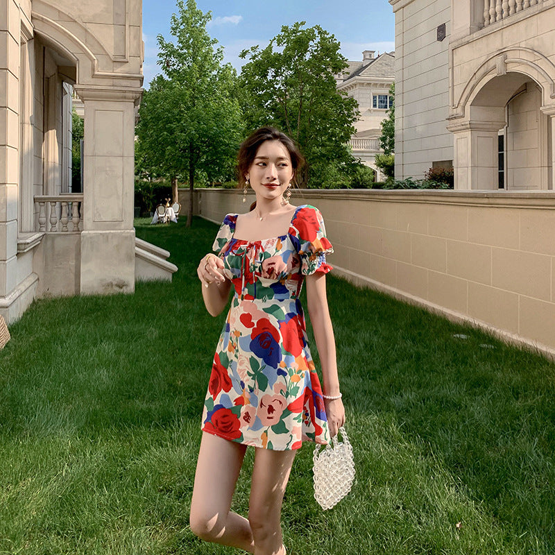Womens summer puff sleeve square neck dress with red, blue, and green floral print, styled for a chic outdoor look.