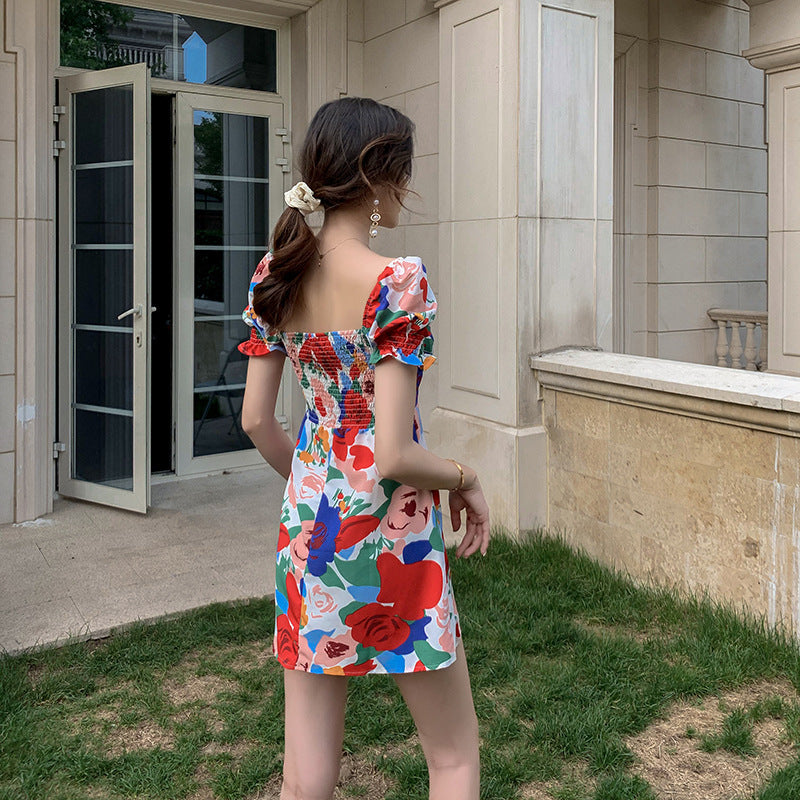Back view of womens summer puff sleeve square neck dress featuring smocked detailing and vibrant floral pattern.